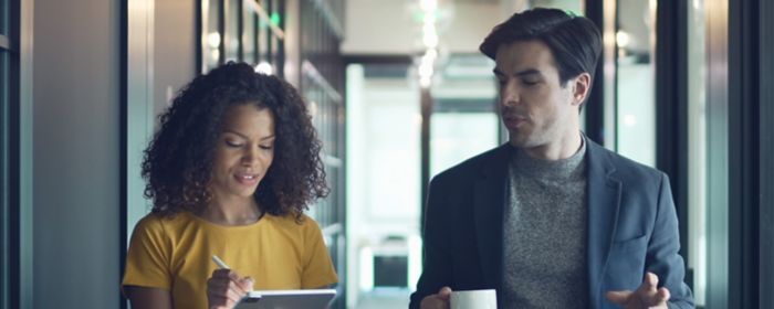 Businesswoman with tablet talking to a colleague