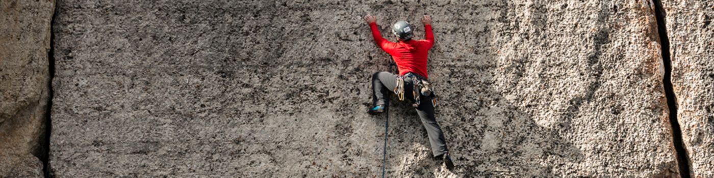 Cliff mountain climber wearing red outfit