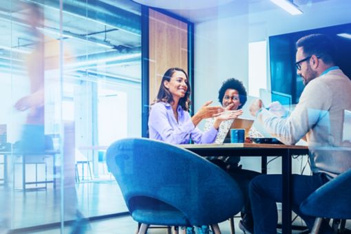 Coworkers sitting in bright office meeting room