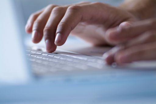 Hands typing on laptop computer