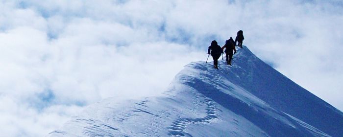Low angle view of hikers on snowy mountain