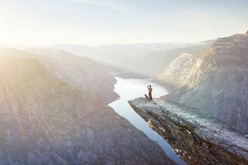 Man and dog on mountain cliff