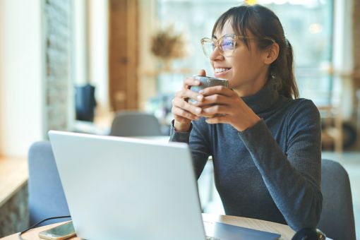 Woman at laptop with coffee