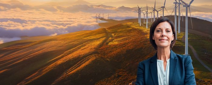 Une femme devant des montagnes et des éoliennes
