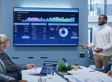 A team meeting in an office with data visualisation on a screen
